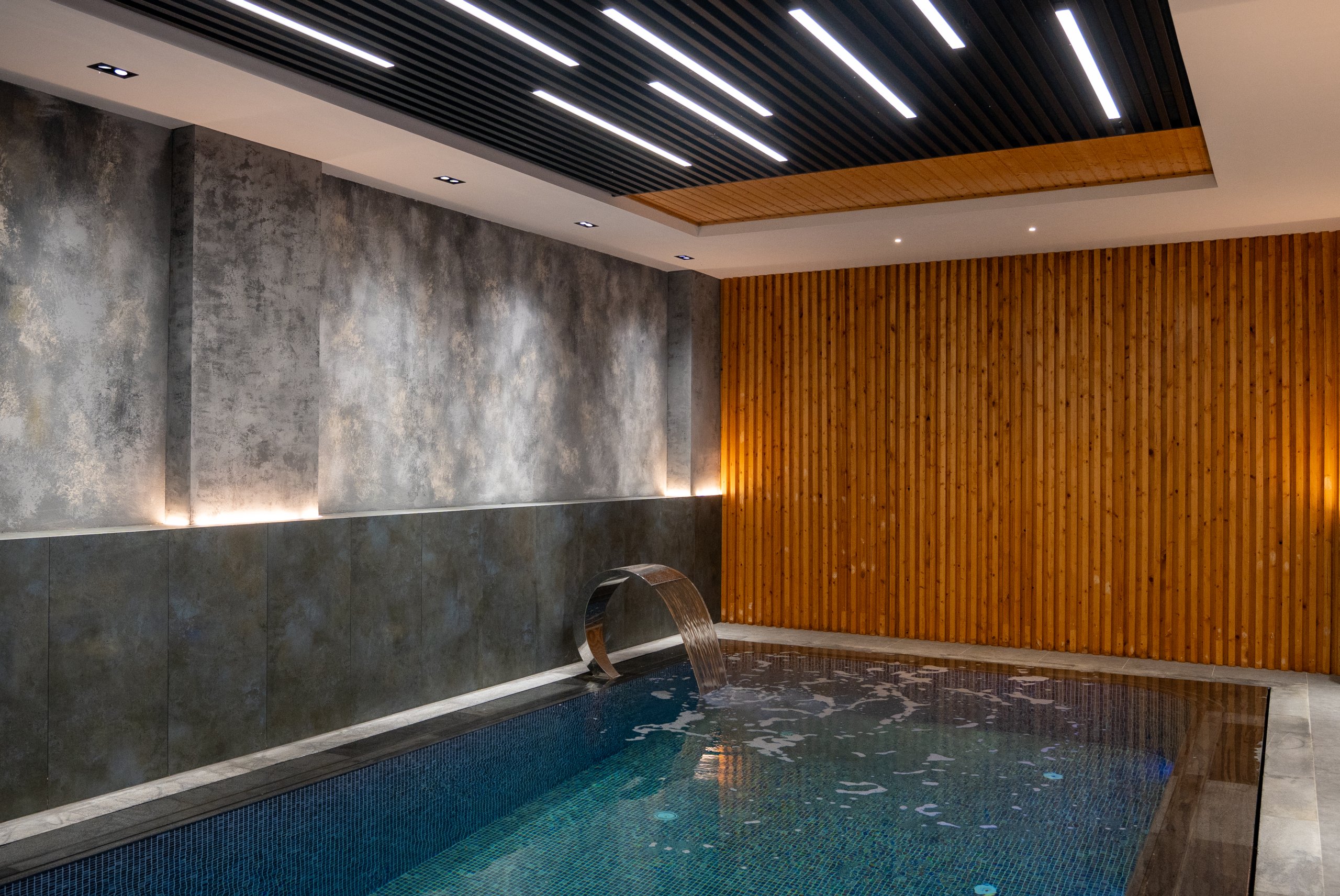 Piscine intérieure moderne éclairage bois design