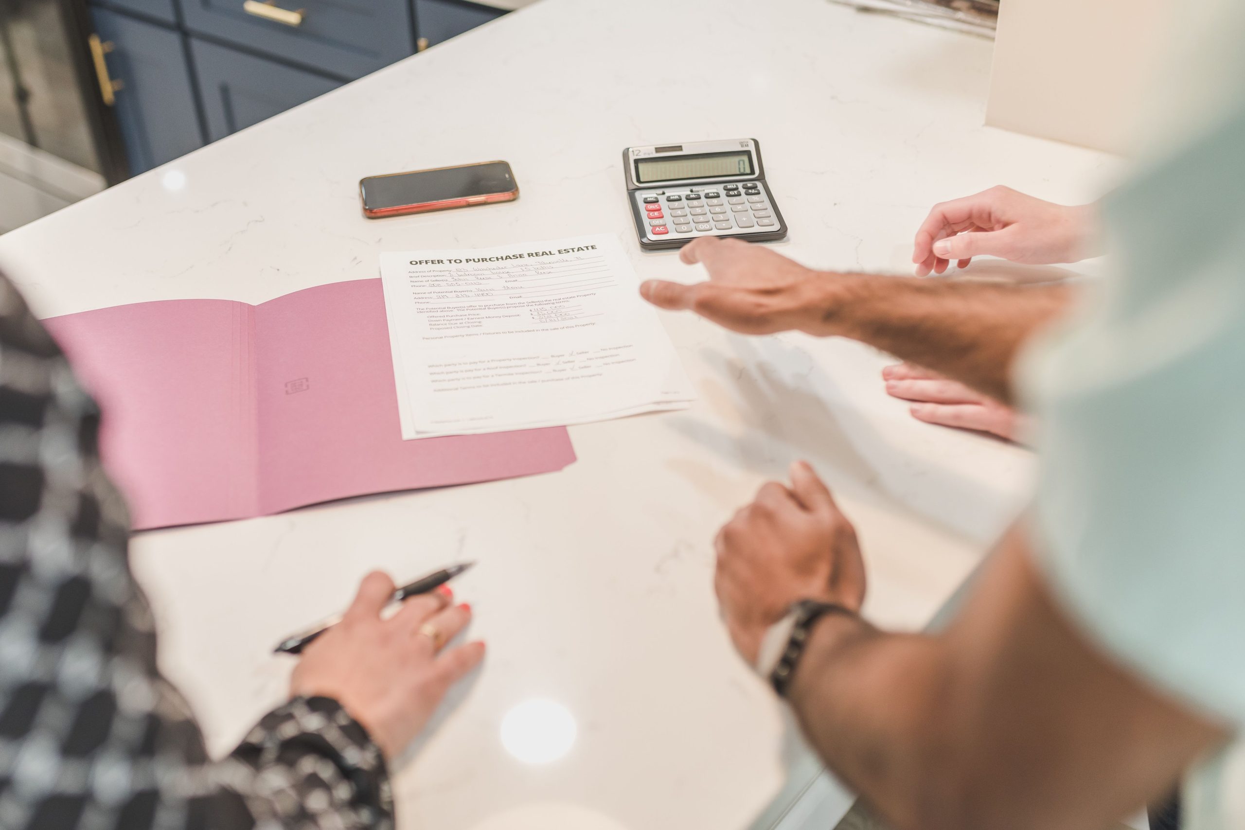 Mains examinant documents immobiliers calculatrice bureau