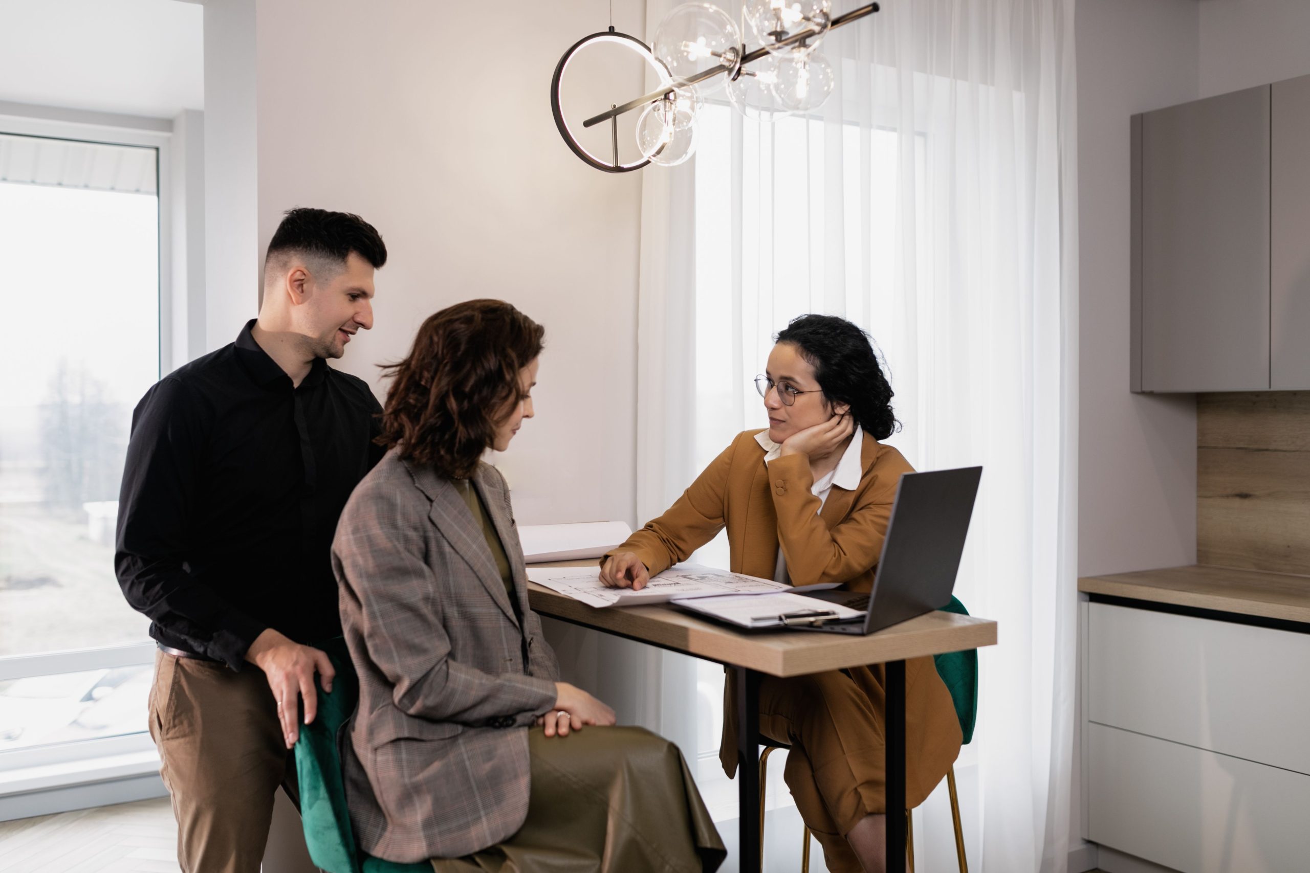 Couple consulte agent immobilier dans bureau moderne