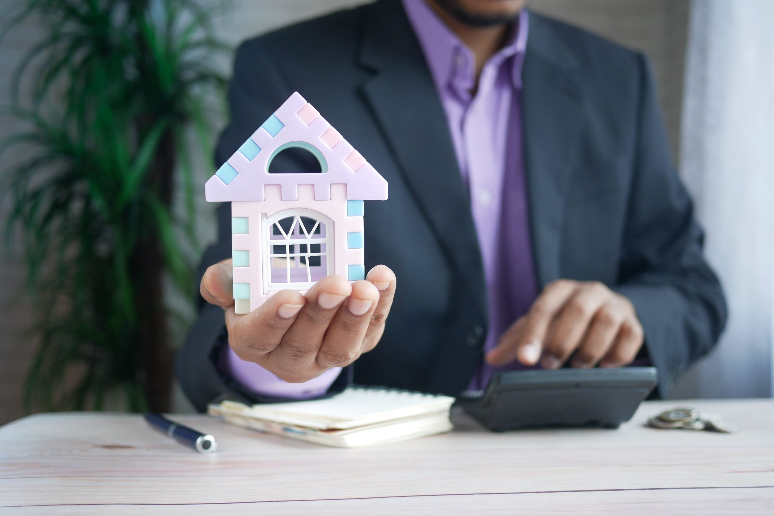 Homme d'affaires calcule investissement immobilier avec maquette