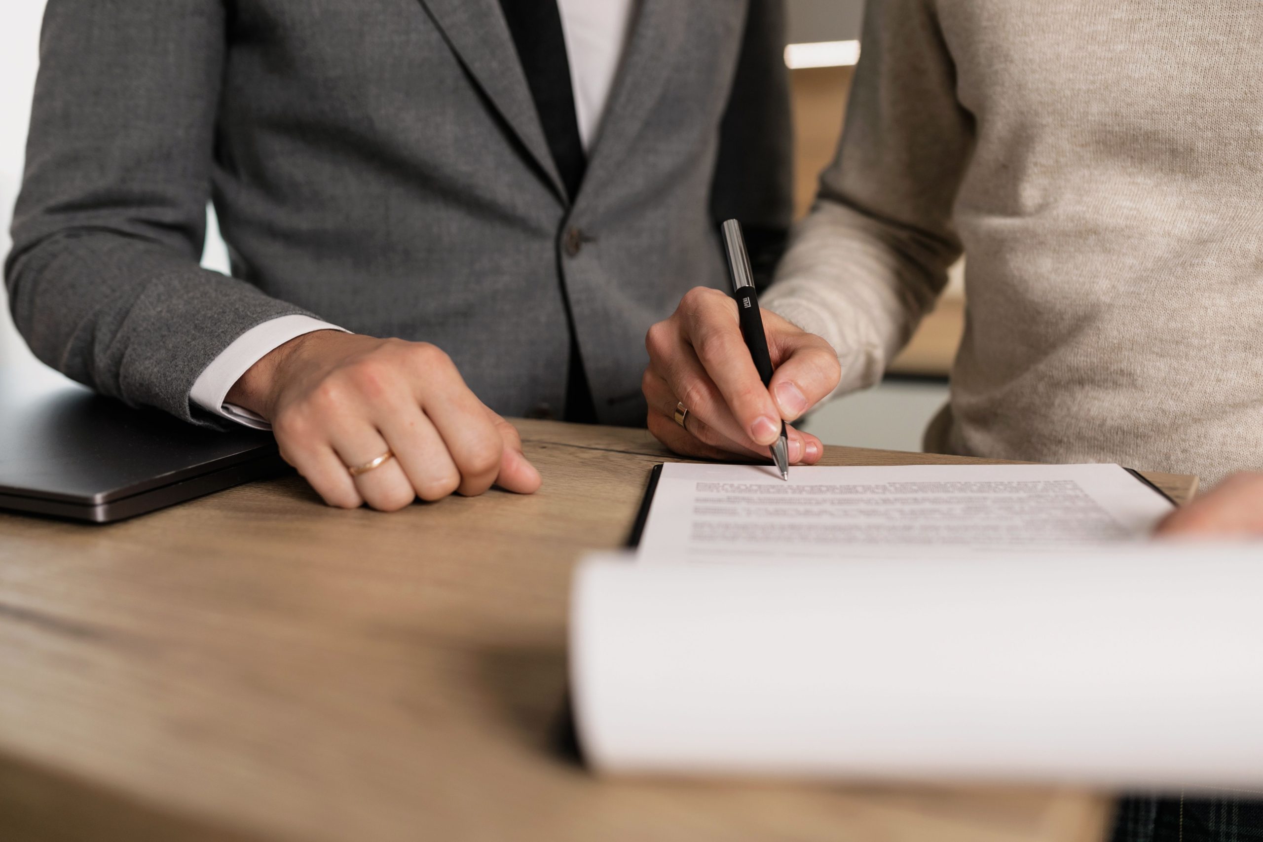 Hommes d'affaires signant documents à table bois